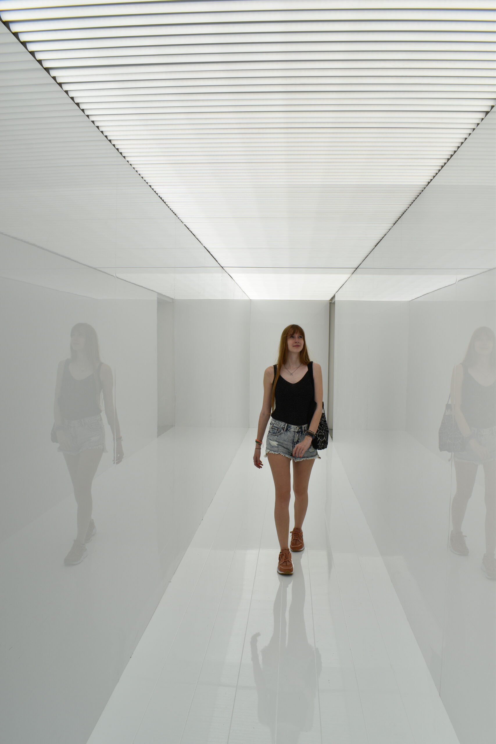 Cristina walking through a corridor of bright light