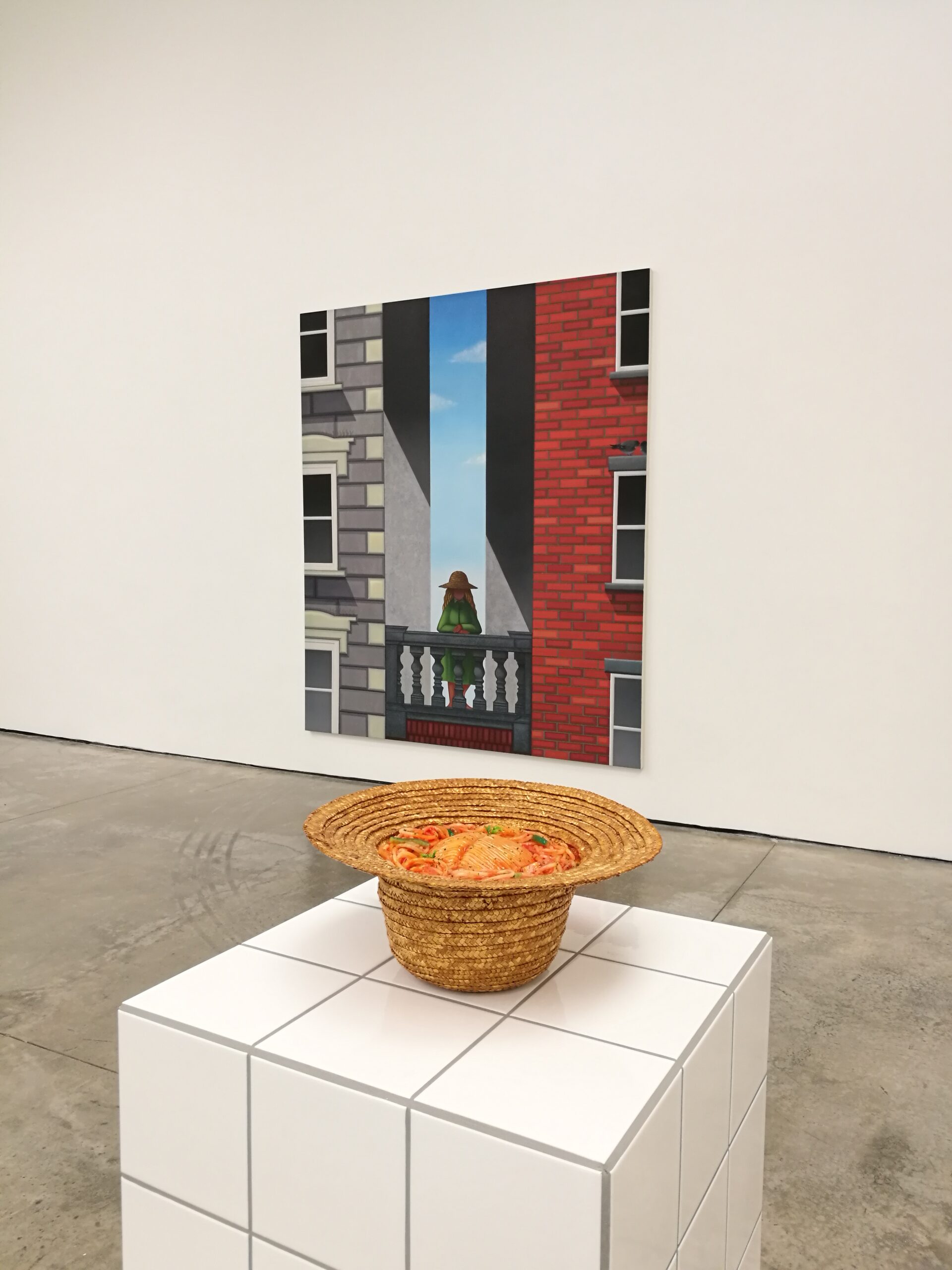 straw hat filled with spaghetti on top of a plinth